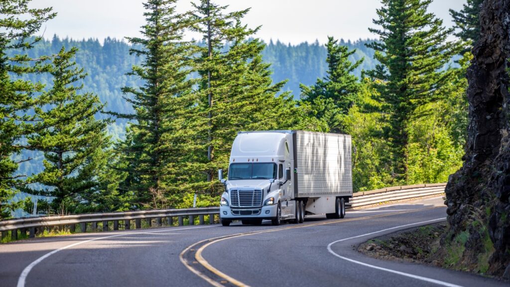 CDL training instructor reviewing compliance documents with a commercial truck driver before a 2027 FMCSA audit.