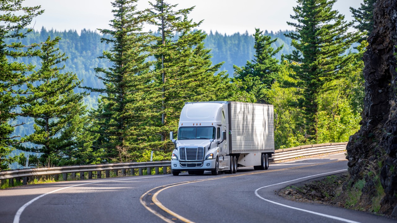 CDL training instructor reviewing compliance documents with a commercial truck driver before a 2027 FMCSA audit.